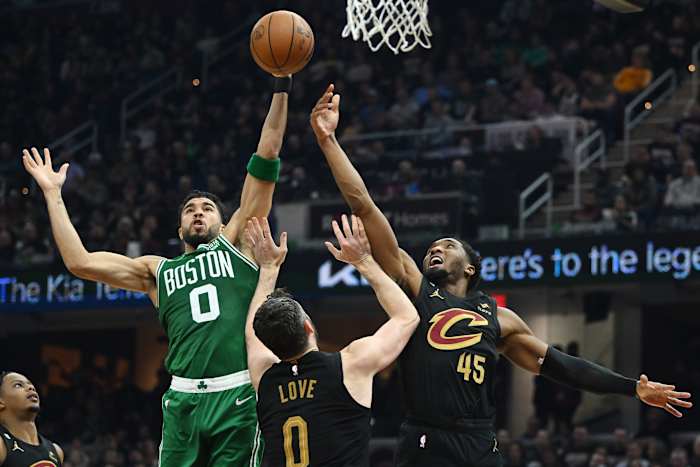 Boston Celtics forward Jayson Tatum competes for a rebound with Cleveland Cavaliers guard Donovan Mitchell